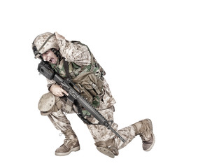 Army soldier in camo uniform, armed with assault rifle and machine gun, crouching to ground,...