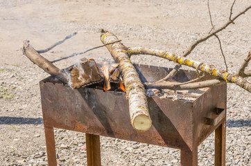 preparation of barbecue for cooking shish kebab; BBQ in the street, smoke