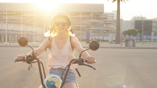 Tourist female wearing helmet taking a tour to exploring around small town with palm alley using electric bicycle for rent