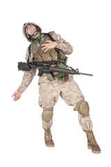 Studio shoot of army soldier in combat uniform and body armor, screaming, clutching chest, dropping weapons and falling down after being fatally shot in military firefight. Marine gets shot in battle