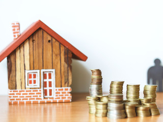 Real estate or property investment concept. coin stack with house model on table.