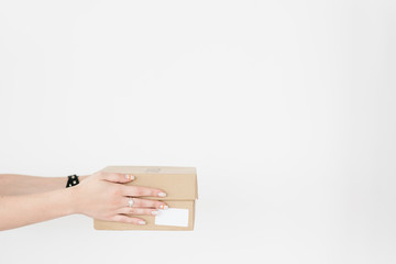 shopping and goods delivery. woman hands holding a cardboard box. online stores and ordering on the internet concept.