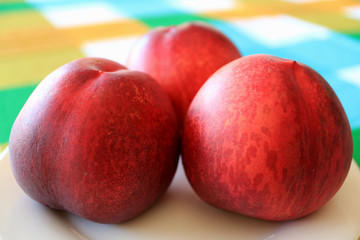 Close Up of Three Fresh Ripe Plum Fruits Served on White Plate  