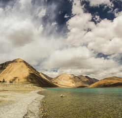Turquoise lake in the Himalayas tibet mountains with clouds and blue sky