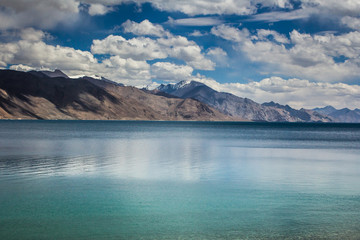 Turquoise lake in the Himalayas tibet mountains with clouds and blue sky