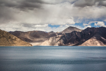 Turquoise lake in the Himalayas tibet mountains with clouds and blue sky