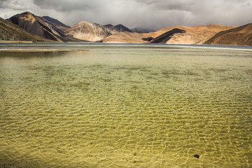 Turquoise lake in the Himalayas tibet mountains with clouds and blue sky