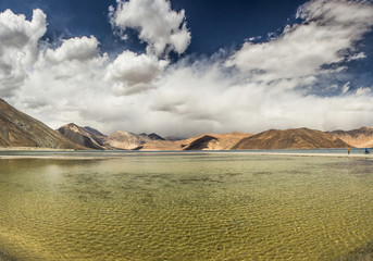 Turquoise lake in the Himalayas tibet mountains with clouds and blue sky