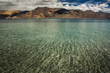 Turquoise lake in the Himalayas tibet mountains with clouds and blue sky