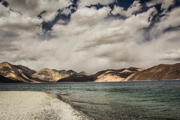 Turquoise lake in the Himalayas tibet mountains with clouds and blue sky