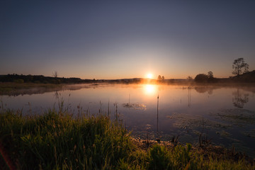 Misty Golden Sunrise Reflecting over Lake in Spring.
