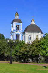 Fototapeta na wymiar Golden domes of Temple of the icon of Our Lady Life-giving Source in Museum-reserve Tsaritsyno in Moscow on a blue sky and green trees background in sunny summer morning