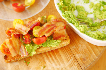 Bacon and tomatoes on avocado toast