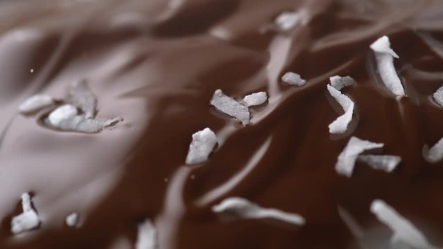 Sprinkling shredded coconut on chocolate. Shot with high speed camera, phantom flex 4K. Slow Motion.