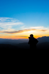 Fototapeta na wymiar Man photographing the mountains at sunset