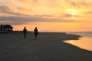Fototapeta na wymiar Mexican Fishermen Walking on Pacific Ocean Beach at Sunrise.