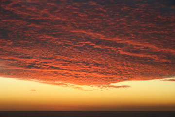 Dramatic Volcanic Crimson Sunset over Pacific Ocean