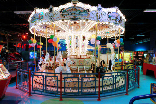 Colorful big carousel with horses and swans