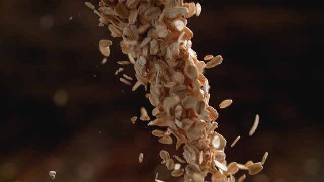 Camera follows throwing oats over a pile of oats. Shot with high speed camera, phantom flex 4K. Slow Motion.