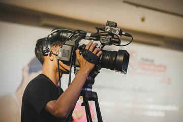 professional cameraman - covering on event with a video
