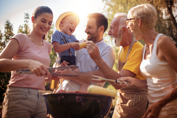 Happy family having barbecue party in backyard