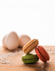 Three macarons on wood with white background