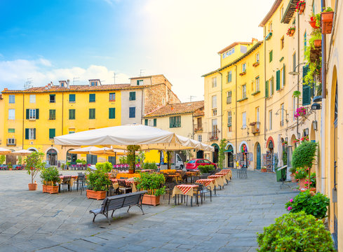 Fototapeta Cafe in the cozy morning lighted square of the city side. Italy. Europe