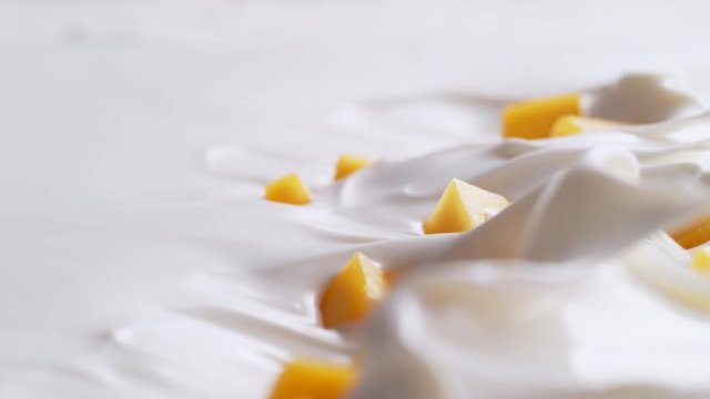 Tossing diced mango in yogurt. Shot with high speed camera, phantom flex 4K. Slow Motion.