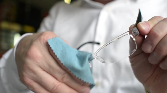 Man Cleaning Glasses sitting at the cafe - solid doctor of Science