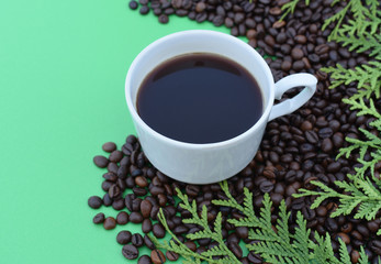 A cup of coffee among coffee beans