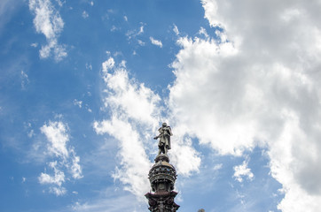 Fototapeta na wymiar Landscape photography of a blue sky with small clouds and a statue of Barcelona.