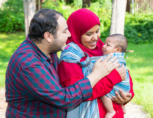 An Arabic couple is talking to their crying baby