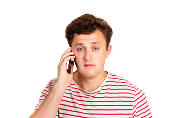 A crying man reads a text message on his phone. Sms with bad news. emotional man isolated on white background