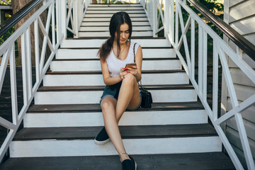 Young woman sitting on wooden staircase in countryside area