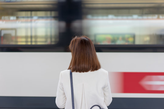 A girl is wating a train in a trian station at Geneva, Switzerland.