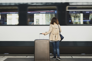 A girl is wating a train in a trian station at Geneva, Switzerland.