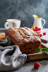 Banana bread with raspberry, bundt on gray concrete vintage background.  Selective focus.