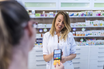 Pharmacist accepting credit card by contactless payment