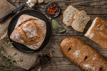 Different fresh bread and spice on rustic wooden background. Creative layout made of bread. Healthy food concept, top view