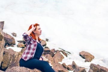 The woman sitting on the rock mountain.