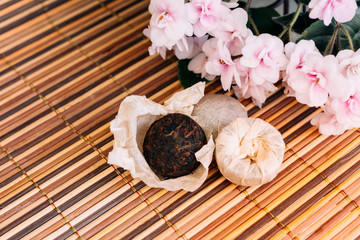 Chinese tea in a block with a paper wrapper on bamboo background