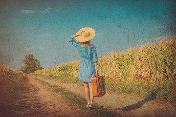 Young girl in dress and hat with suitcase walking along a rural road. Image in old dirty paper style