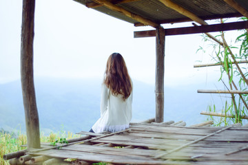 Young lonely woman sitting in cottage and looking view of nature, Relaxation on vacation trip