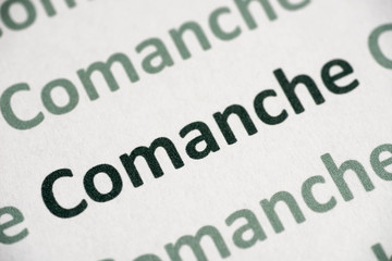 word Comanche language printed on paper macro