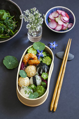 Bento box with onigiri, prawns and vegetables