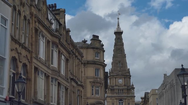 Time lapse. Clouds above the houses and the clock tower. England.