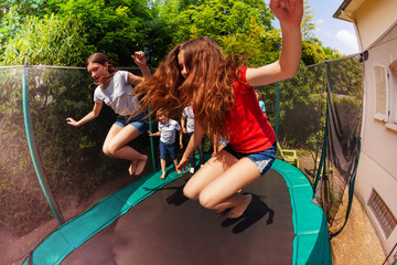 Girls and boys bouncing on the outdoor trampoline