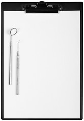 Surgical Tools and a Sheet of Paper on the Black Clipboard -