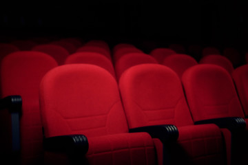 Obraz premium Many rows of red velvet seats in a cinema or theater stage, in semi-darkness. 