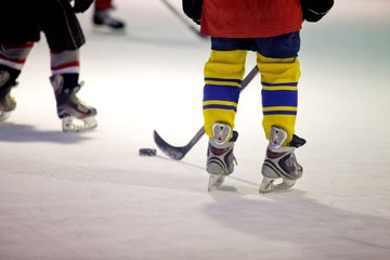 Closeup of Child Legs in Ice Hockey in Arena